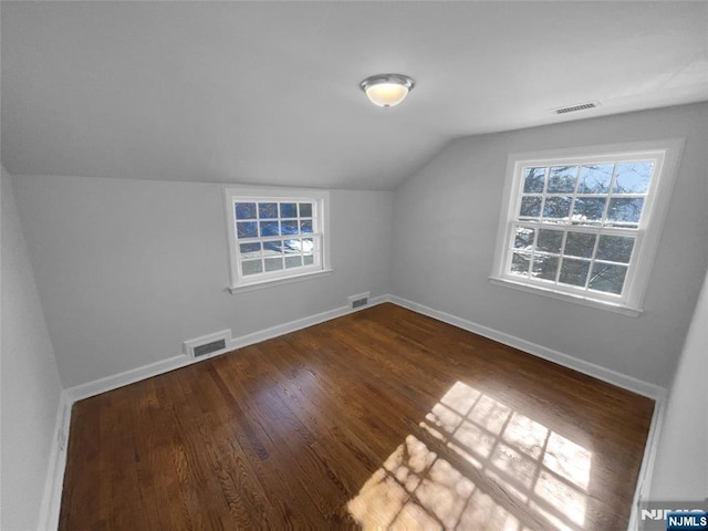 additional living space featuring visible vents, baseboards, and dark wood-style flooring