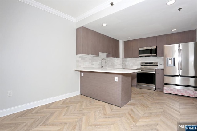 kitchen with baseboards, stainless steel appliances, light countertops, crown molding, and backsplash