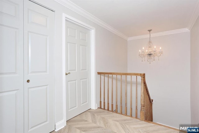 corridor with crown molding, an upstairs landing, and a chandelier