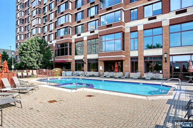 community pool featuring a patio and fence