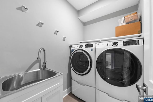 laundry area with cabinet space, washer and dryer, baseboards, and a sink