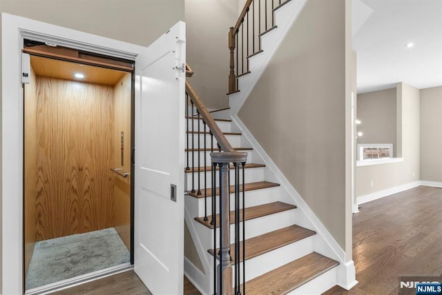 stairs with elevator, recessed lighting, baseboards, and wood finished floors