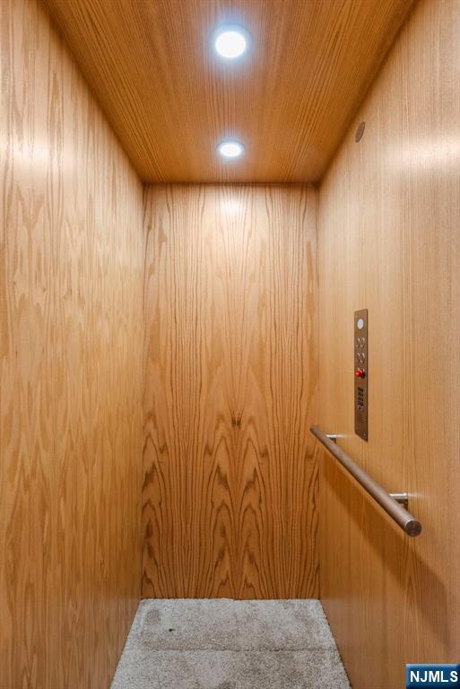 details with wooden ceiling, elevator, and recessed lighting