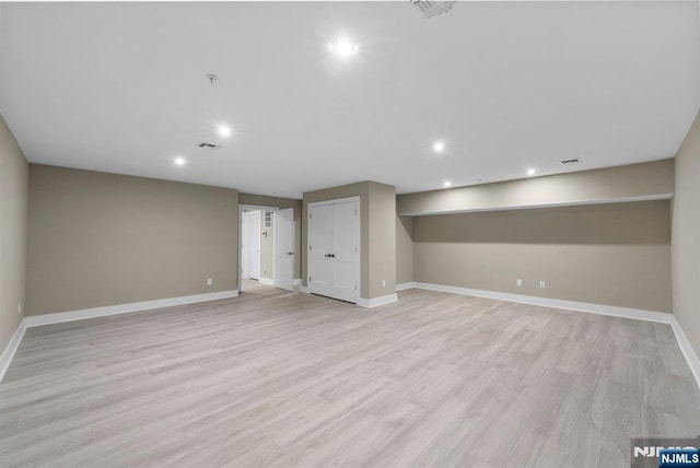 finished below grade area with visible vents, recessed lighting, baseboards, and light wood-type flooring