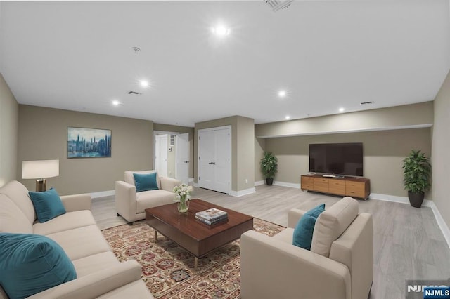 living area featuring visible vents, recessed lighting, baseboards, and light wood-style floors