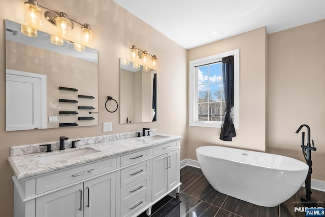 bathroom with a soaking tub, baseboards, and a sink