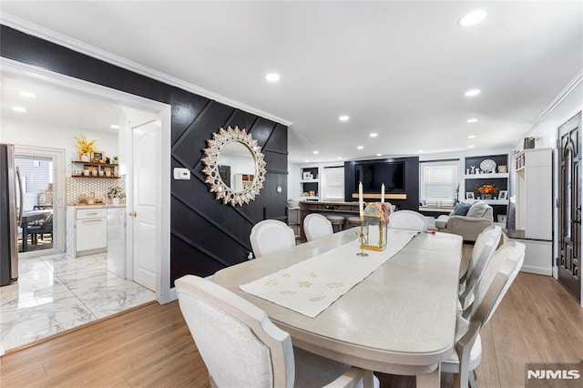 dining area with crown molding, recessed lighting, and light wood finished floors