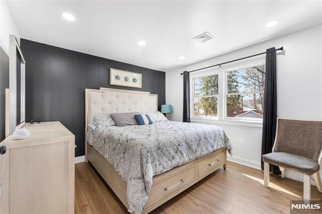 bedroom featuring recessed lighting, visible vents, baseboards, and light wood finished floors