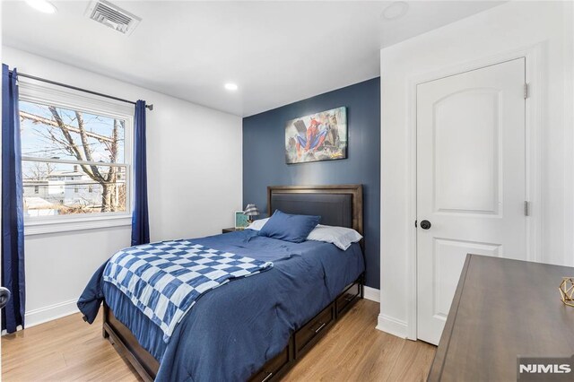 bedroom with recessed lighting, visible vents, baseboards, and light wood finished floors