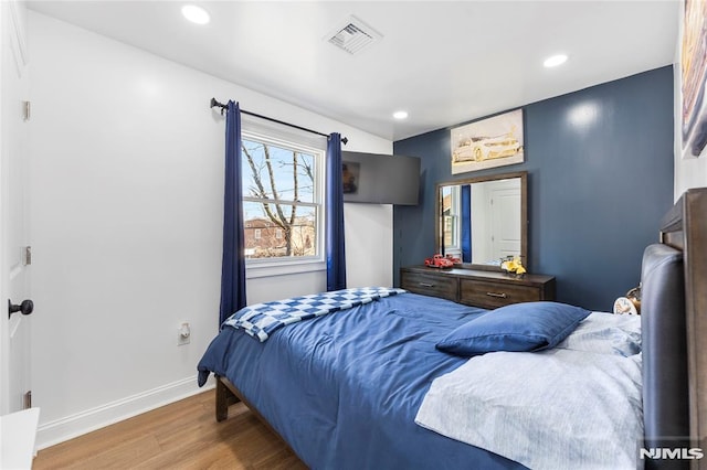 bedroom with visible vents, recessed lighting, baseboards, and wood finished floors