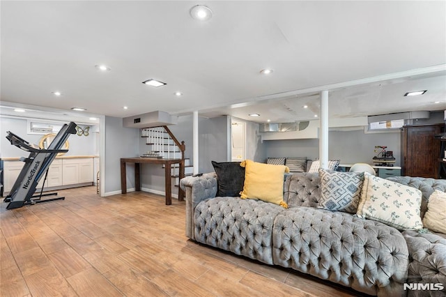 living area featuring recessed lighting, light wood-type flooring, baseboards, and stairway