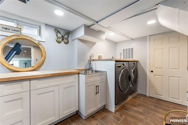 washroom featuring wood finish floors, separate washer and dryer, recessed lighting, and a sink