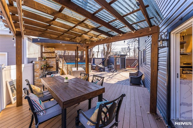 wooden terrace with outdoor dining area, fence, and a fenced in pool