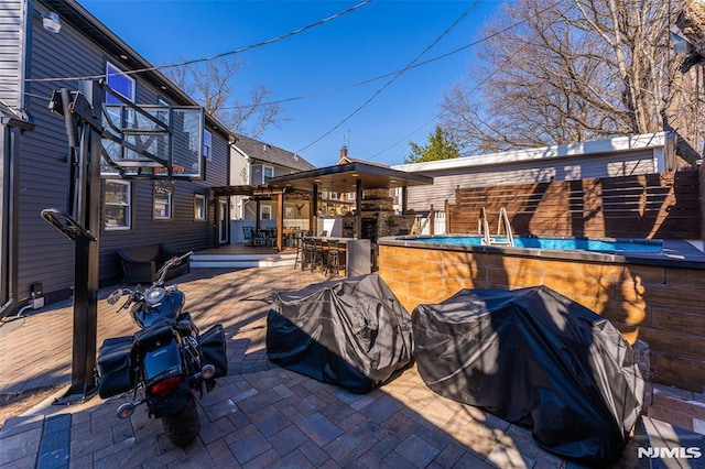 view of patio with outdoor dry bar and a grill