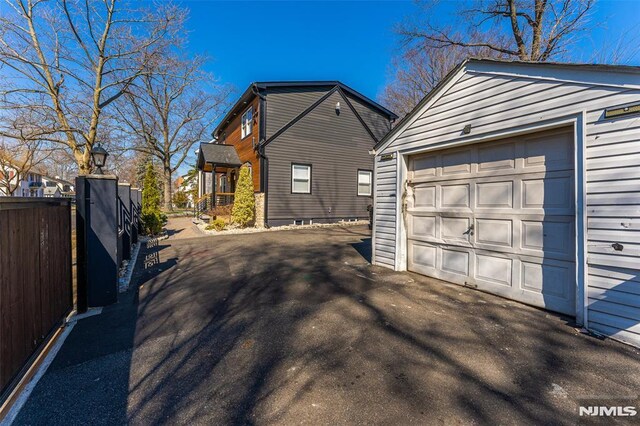 detached garage with driveway and fence