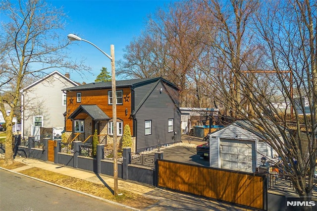 view of front of house featuring a fenced front yard, a garage, an outdoor structure, and a gate