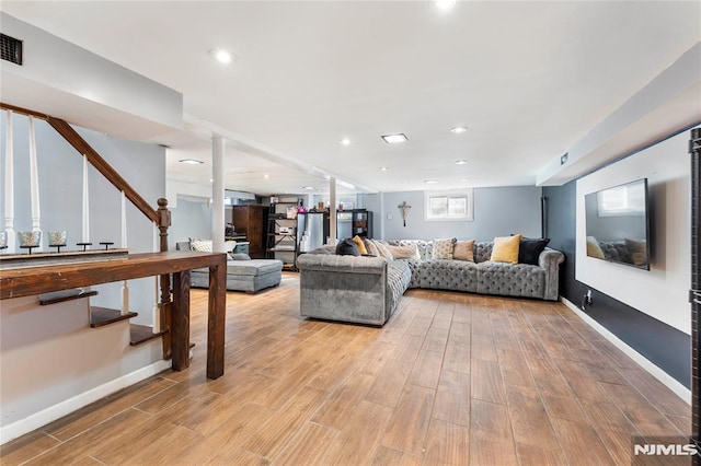 living area featuring visible vents, baseboards, stairway, recessed lighting, and light wood-style flooring