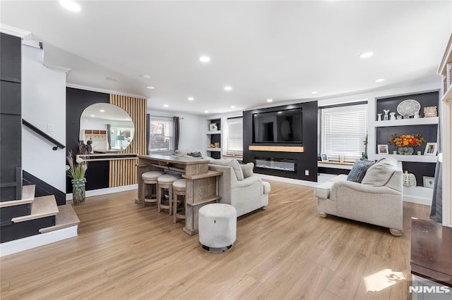 living room with built in shelves, light wood-style floors, and recessed lighting