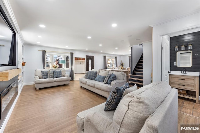 living area featuring recessed lighting, wood finished floors, stairs, and ornamental molding