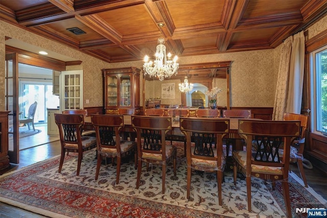 dining space with crown molding, wooden ceiling, wainscoting, and wallpapered walls