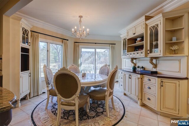 dining area featuring crown molding, a notable chandelier, and light tile patterned flooring