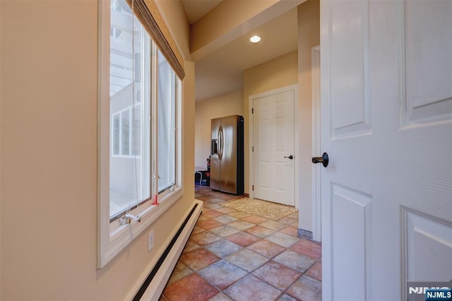 interior space with a baseboard radiator and stone finish floor