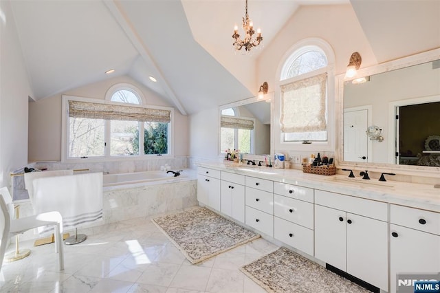 full bath with a notable chandelier, marble finish floor, a sink, double vanity, and a bath