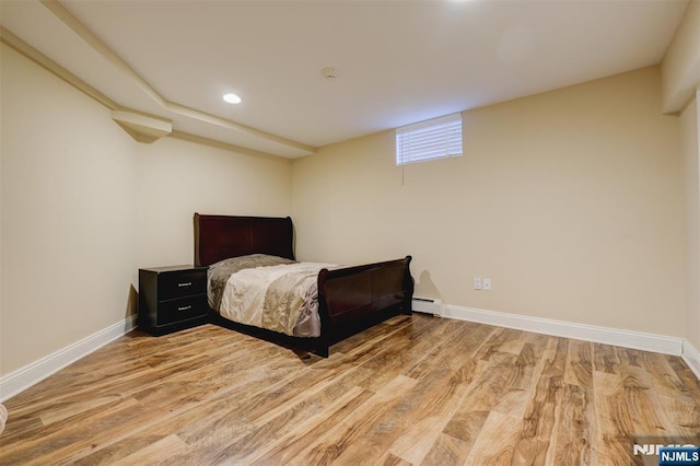 bedroom with a baseboard heating unit, light wood-style flooring, recessed lighting, and baseboards