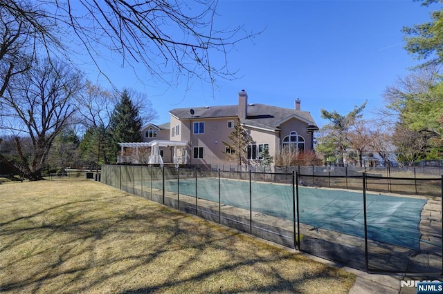 view of swimming pool featuring a yard, a fenced in pool, a pergola, and fence