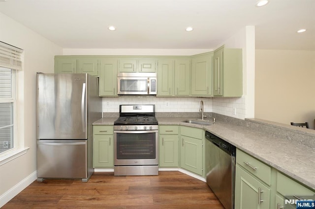 kitchen with green cabinets, a sink, and stainless steel appliances