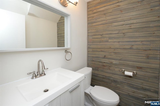 half bathroom with vanity and toilet