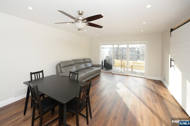 dining area with a ceiling fan, wood finished floors, baseboards, recessed lighting, and a barn door