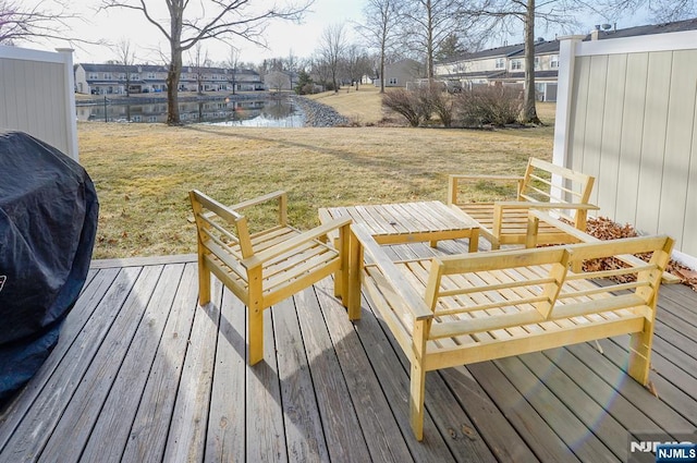 wooden terrace featuring a yard and a water view