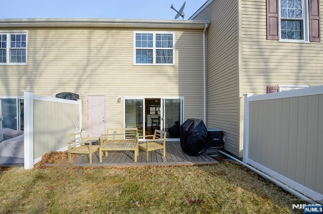 back of house with a wooden deck, a yard, and fence