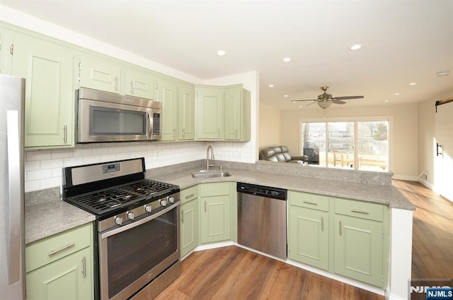 kitchen featuring a sink, stainless steel appliances, and green cabinets