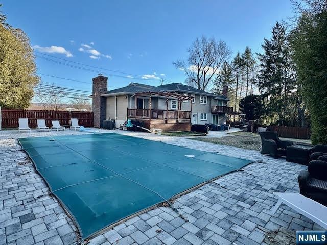 view of swimming pool with a patio, fence, a fenced in pool, and a wooden deck