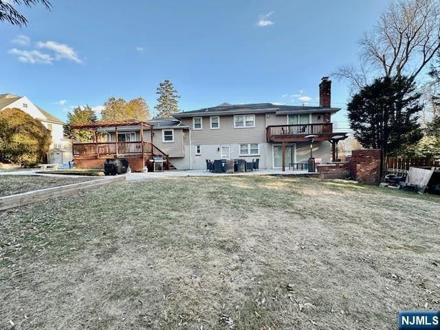 back of house featuring a wooden deck and a chimney