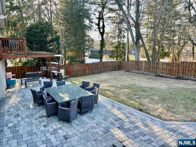 view of patio featuring outdoor dining space, a fenced backyard, and a pergola