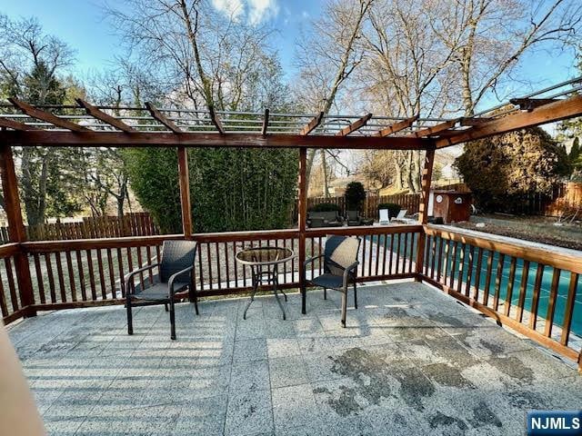 deck featuring a patio area, a pergola, and fence