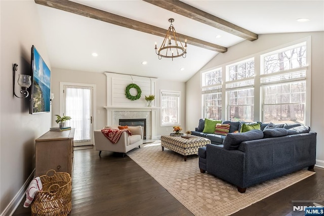 living area featuring baseboards, lofted ceiling with beams, an inviting chandelier, dark wood-style floors, and a glass covered fireplace