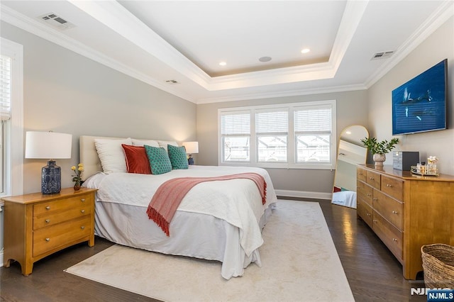 bedroom with a tray ceiling, visible vents, dark wood-style flooring, and crown molding