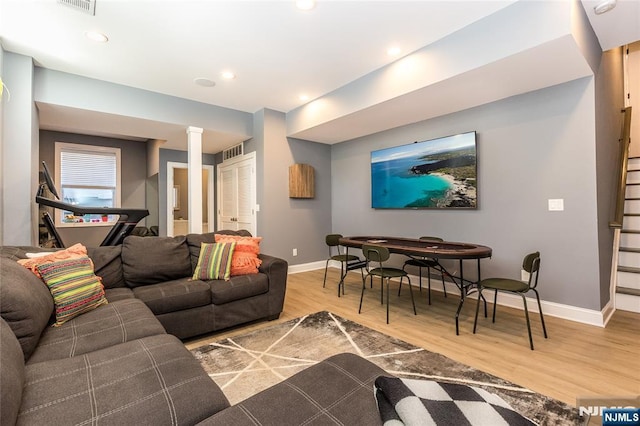 living room with recessed lighting, visible vents, baseboards, and wood finished floors