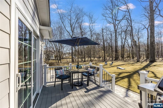 wooden terrace featuring a lawn