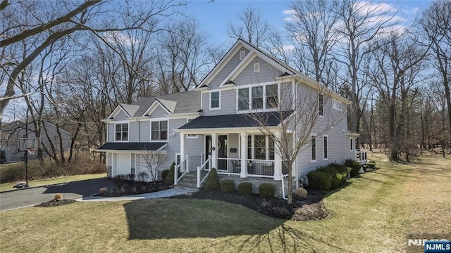 view of front of house featuring aphalt driveway, covered porch, a front yard, and a shingled roof