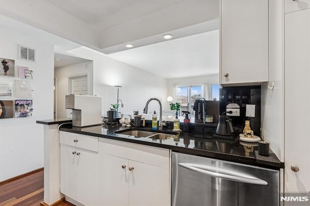 kitchen featuring visible vents, a sink, dark countertops, white cabinets, and dishwasher