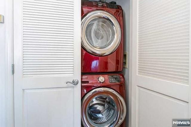 clothes washing area featuring laundry area and stacked washing maching and dryer