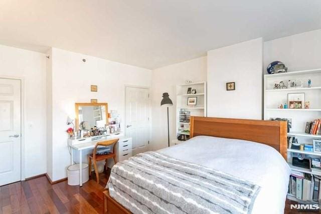 bedroom with dark wood-type flooring