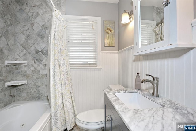 full bath featuring wainscoting, vanity, toilet, and shower / bathtub combination with curtain