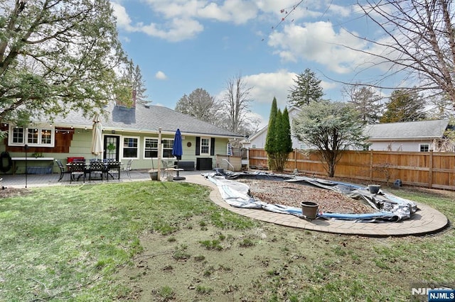 rear view of house featuring a patio area, fence, a lawn, and a chimney