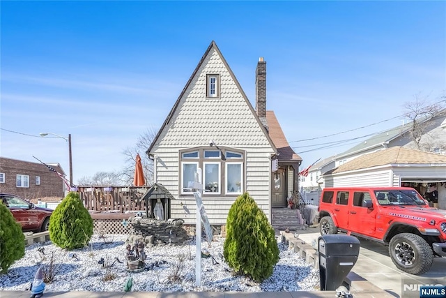 exterior space featuring a chimney and roof with shingles